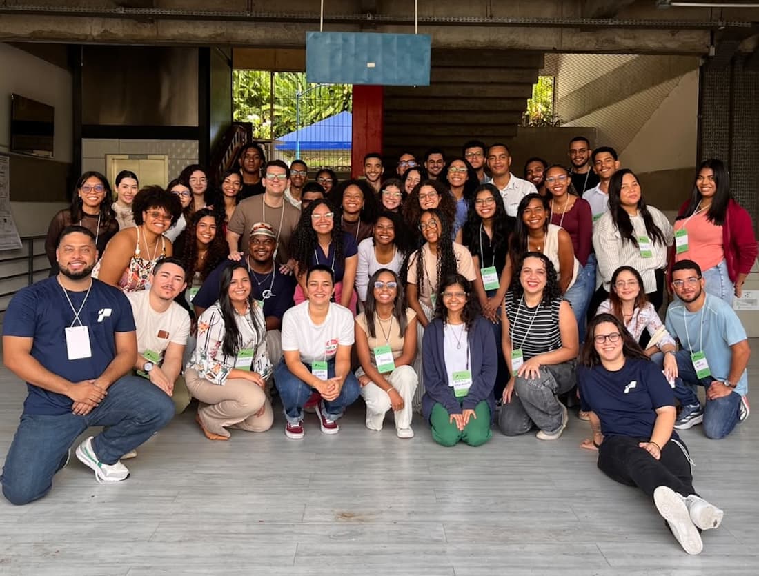 Grupo de cerca de 25 jovens posando para foto em prédio de universidade em Salvador